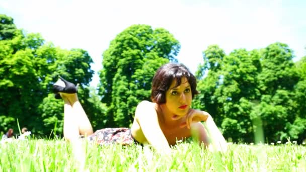 Schönes Mädchen mit kurzen Haaren liegt im öffentlichen Garten in Parma — Stockvideo
