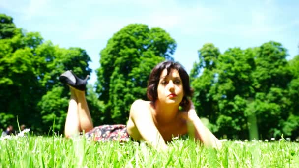 Schönes Mädchen mit kurzen Haaren liegt im öffentlichen Garten in Parma — Stockvideo