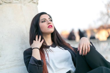 Güzel esmer, uzun saçlı, ceketli, siyah pantolonlu, padualı bir kız. Yüksek kalite fotoğraf