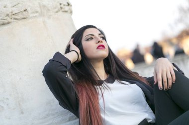 Güzel esmer, uzun saçlı, ceketli, siyah pantolonlu, padualı bir kız. Yüksek kalite fotoğraf