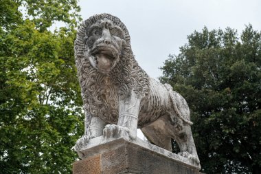 Medieval lion statue in the park of the ancient city walls of Lucca, Italy. High quality photo