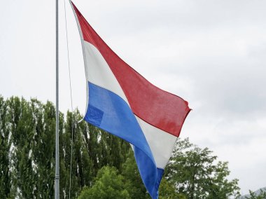 Hollanda bayrağı bulutlu gökyüzünde dalgalanıyor. Yüksek kalite fotoğraf
