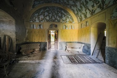 Terk edilmiş eski bir evde kanepesi ve koltukları olan bir oturma odası. Yüksek kalite fotoğraf