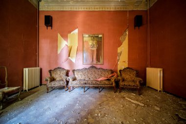 Terk edilmiş eski bir evde kanepesi ve koltukları olan bir oturma odası. Yüksek kalite fotoğraf