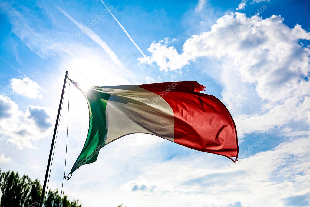 Italian flag waving over blue sky. High quality photo