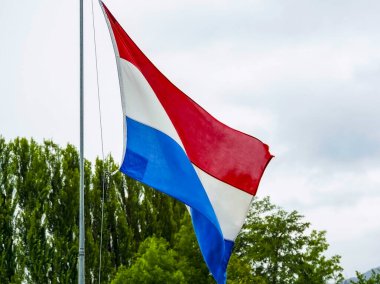 Hollanda bayrağı bulutlu gökyüzünde dalgalanıyor. Yüksek kalite fotoğraf