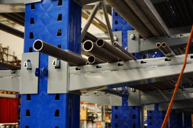 Metal işçiliği için fabrikadaki bir rafa konacak çelik borular. Yüksek kalite fotoğraf