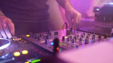 Diskodaki DJ ellerini konsolun üzerine koyuyor.