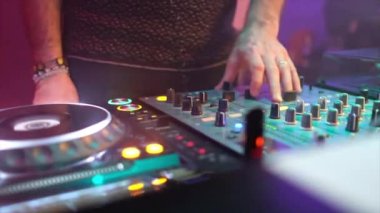 Diskodaki DJ ellerini konsolun üzerine koyuyor.