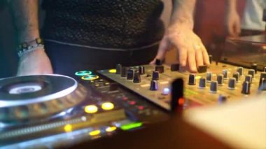Diskodaki DJ ellerini konsolun üzerine koyuyor.