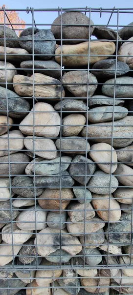 wall of river stones in metal cage. High quality photo