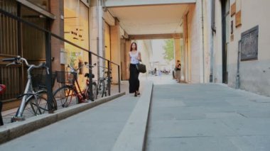 Güzel esmer kız, Reggio Emilia 'nın şehir merkezinin sokaklarında yürüyor.