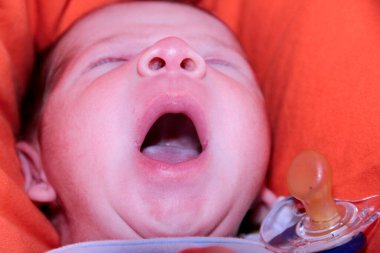 Yeni doğmuş bebek kanepenin üzerinde ağzı açık esniyor. Yüksek kalite fotoğraf