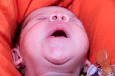 Yeni doğmuş bebek kanepenin üzerinde ağzı açık esniyor. Yüksek kalite fotoğraf