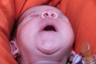 Yeni doğmuş bebek kanepenin üzerinde ağzı açık esniyor. Yüksek kalite fotoğraf