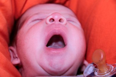 Yeni doğmuş bebek kanepenin üzerinde ağzı açık esniyor. Yüksek kalite fotoğraf