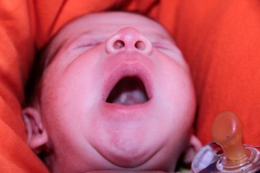 Yeni doğmuş bebek kanepenin üzerinde ağzı açık esniyor. Yüksek kalite fotoğraf