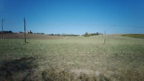 Vista de um carro que se move em uma estrada entre campos verdes — Vídeo de Stock