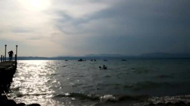 Sirmione 'de güzel bir gün batımı ve Garda Gölü' nde iskeleli.