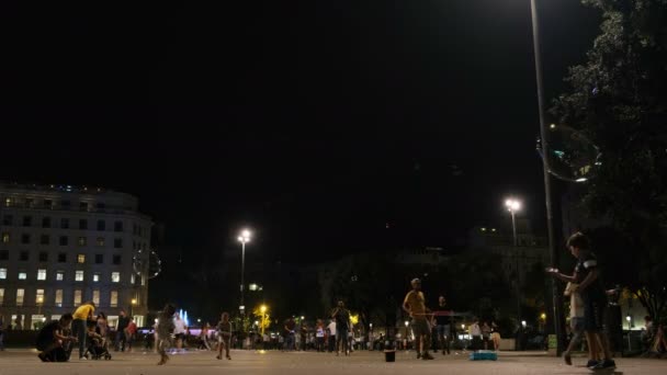 Kinder spielen am Abend mit Seifenblasen auf einem Platz in Barcelona, Spanien — Stockvideo