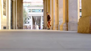 Genç adam verandada seyahat çantasıyla dolaşıyor.