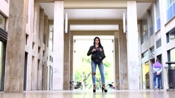 아름다운 젊은 여자가 이탈리아 레조 에밀리아 시내 의산 로스코 건물을 따라 걷고 있다 — 비디오