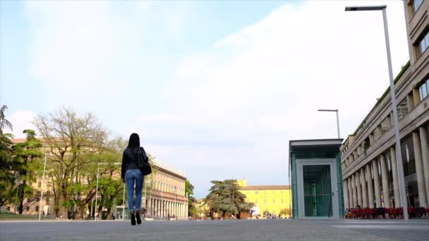 Mooie jonge vrouw wandelen langs San Rocco gebouw in Reggio Emilia centrum, Italië — Stockvideo