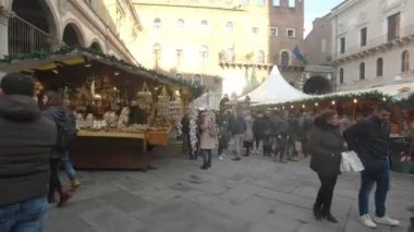 Verona - İtalya - 12: 23: 2018: Verona 'nın merkezindeki geleneksel Noel pazarının tezgahları arasında yürüyen insanlar