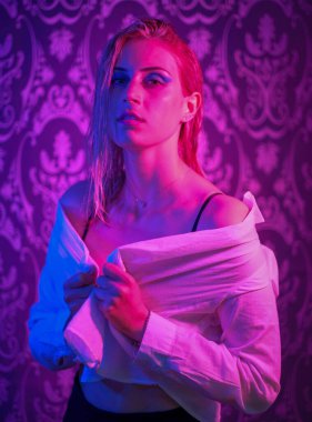 beautiful blonde italian girl posing in photo studio with colorful lights. High quality photo