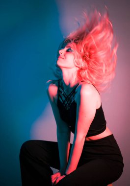 beautiful blonde italian girl posing in photo studio with colorful lights. High quality photo