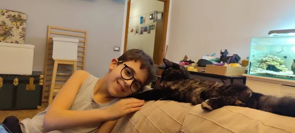 Niño Con Gafas Juega Con Gato Sofá Foto Alta Calidad — Foto de Stock