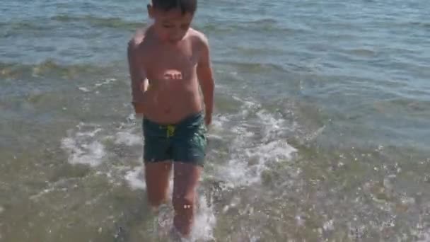 Hermoso niño en el mar juega en las olas en Rímini Riccione Italia — Vídeos de Stock