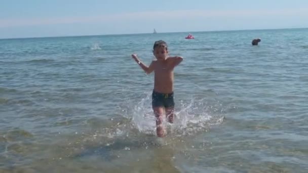 Beautiful child at the sea plays in the waves in Rimini Riccione Italy — Stock Video