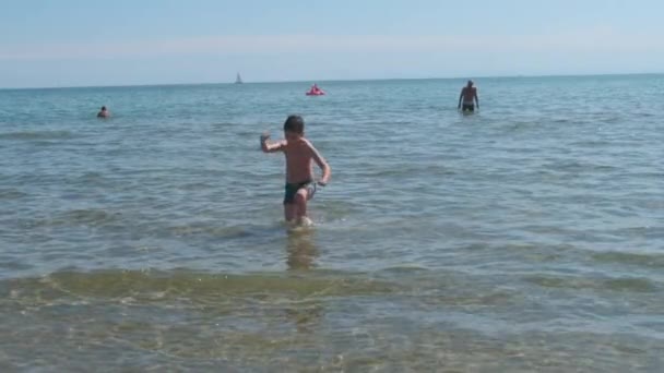 Schönes Kind am Meer spielt in den Wellen in Rimini Riccione Italien — Stockvideo