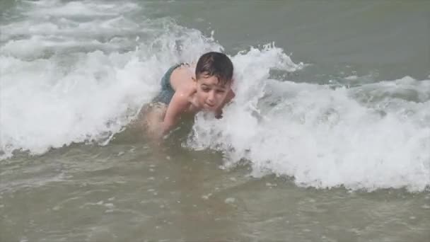 Hermoso niño en el mar juega en las olas en Rímini Riccione Italia — Vídeos de Stock