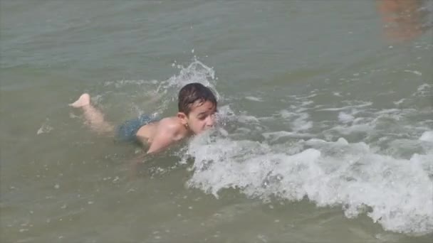 Hermoso niño en el mar juega en las olas en Rímini Riccione Italia — Vídeos de Stock