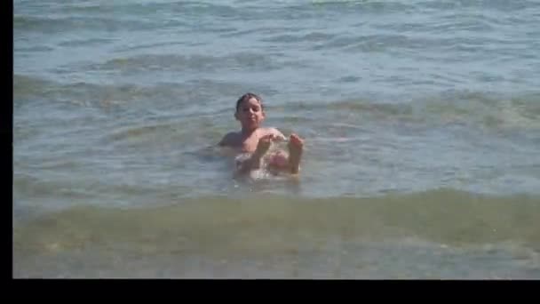 Hermoso niño en el mar juega en las olas en Rímini Riccione Italia — Vídeos de Stock