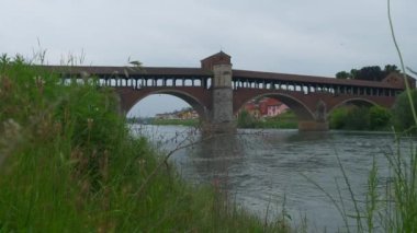 Pavia köprüyü arabalarla ve Ticino Nehri 'ni gören yayalarla kapladı. Yüksek kalite 4k görüntü