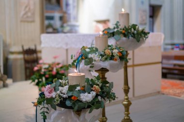 Katolik düğünü için sunaktaki çiçeklerle süslenmiş mum. Yüksek kalite fotoğraf