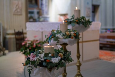 Katolik düğünü için sunaktaki çiçeklerle süslenmiş mum. Yüksek kalite fotoğraf