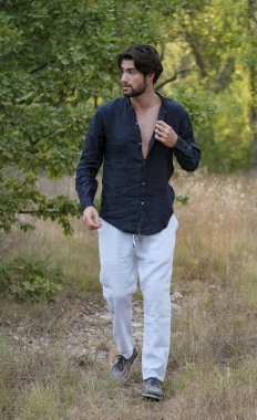 Koyu renk saçlı İtalyan modelin portresi açık renk gözlü ve siyah gömlekli ve ağaçlarda sakallı. Yüksek kalite fotoğraf