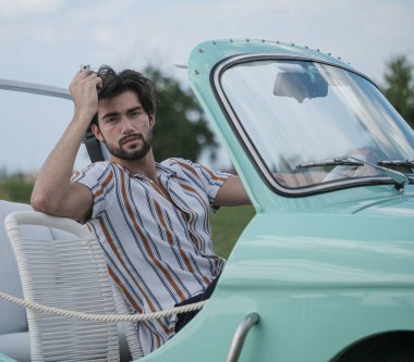 Eskimiş İtalyan Tiffany arabasında sakallı, açık renk gözlü, güzel, siyah saçlı İtalyan bir modelin portresi. Yüksek kalite fotoğraf