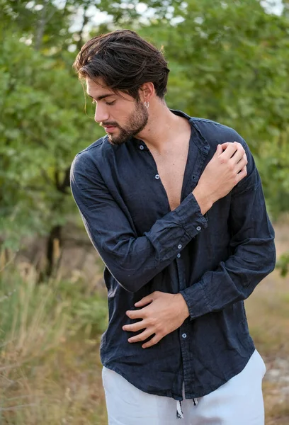 Koyu renk saçlı İtalyan modelin portresi açık renk gözlü ve siyah gömlekli ve ağaçlarda sakallı. Yüksek kalite fotoğraf