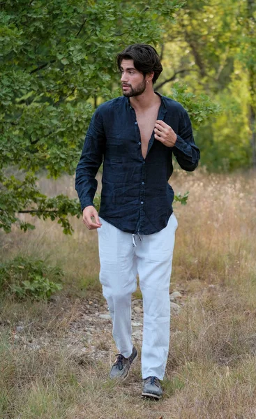 Koyu renk saçlı İtalyan modelin portresi açık renk gözlü ve siyah gömlekli ve ağaçlarda sakallı. Yüksek kalite fotoğraf