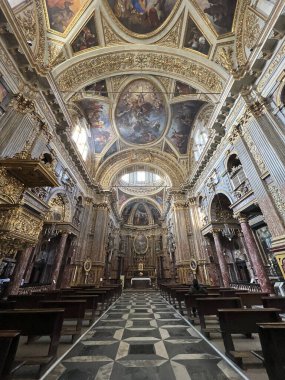 Süslü altın, mermer sütunlar, yüksek tavanlar ve sunağa uzanan kalın desenli mermer döşeme ile zengin bir Barok kilise nav 'ının nefes kesici simetrik görüntüsü. Yüksek kalite fotoğraf