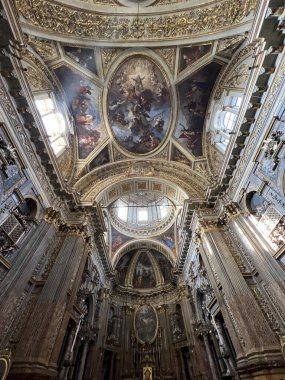 Süslü altın, mermer sütunlar, yüksek tavanlar ve sunağa uzanan kalın desenli mermer döşeme ile zengin bir Barok kilise nav 'ının nefes kesici simetrik görüntüsü. Yüksek kalite fotoğraf