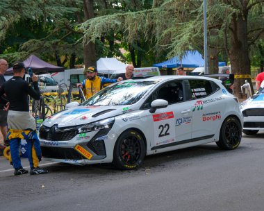 Salsomaggiore Terma Parma, İtalya: 2025 08 03 ACI Team Italia 'nın 22 numaralı beyaz Renault Clio rali arabası takım üyeleriyle çevrili bir motor sporu etkinliği sırasında servis çayırında park edilmiştir. Yüksek kalite fotoğraf