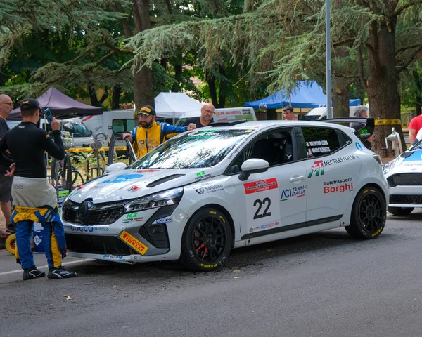 Salsomaggiore Terma Parma, İtalya: 2025 08 03 ACI Team Italia 'nın 22 numaralı beyaz Renault Clio rali arabası takım üyeleriyle çevrili bir motor sporu etkinliği sırasında servis çayırında park edilmiştir. Yüksek kalite fotoğraf