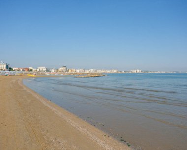 Sakin Adriyatik Denizi boyunca uzanan Cattolica 'daki kumlu bir sahil şeridi berrak mavi bir gökyüzünün altında. Yüksek kalite fotoğraf