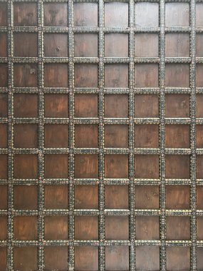 Görüntü, karelerin yer aldığı duvarın detaylı bir görüntüsünü gösteriyor. Kare tuğlalar ya da ahşap leke kahverengi bir renk, sert ahşap bir zemin karşı kurulmuş